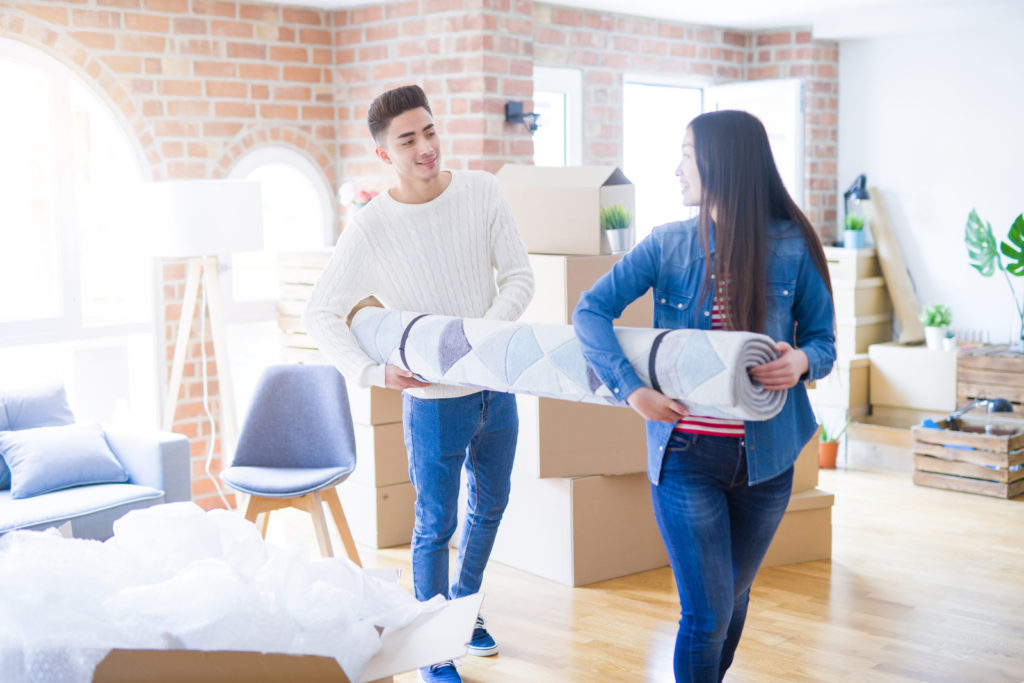 Couple Packing A Rug For Moving